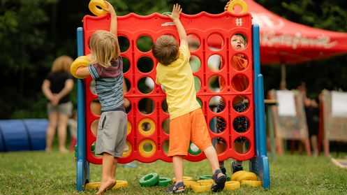 Kinder beim Spielen vor einer Spielwand