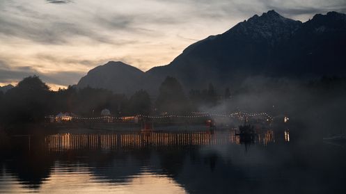 Baggersee mit Bergen im Hintergrund